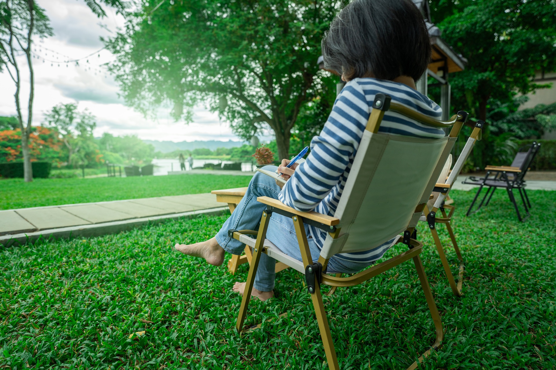 Frau entspannt schreibend im Garten | Wellnesshotel